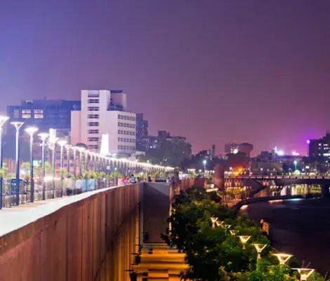 An Ahmedabad city at night with a river and buildings